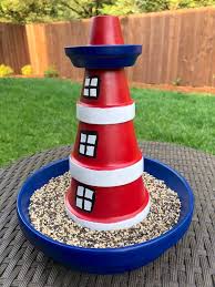 Wooden lawn lighthouse that shows off a natural, unpainted appearance. Lighthouse Bird Feeder With Terra Cotta Pots Mod Podge Rocks
