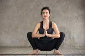 Group of people practicing yoga, head to knee forward bend. 8 Easy Yoga Poses With Big Health Benefits Goodnet