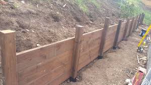 Retaining walls are, thus, used to bound two soils between two different terrain elevations in normal walls are built to bear vertical loads while retaining walls are dealing with horizontal loads. How Do I Protect The Front Side Of A Wood Retaining Wall Home Improvement Stack Exchange