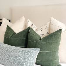 teal and sage green decorative pillows on white sofa