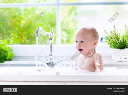 If this is the case, or if your baby isn't quite able to sit up yet, try making the move to the big tub by using a bath seat under your constant supervision. Baby Taking Bath Image Photo Free Trial Bigstock