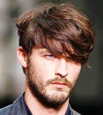 Hairstyles For Medium Length Hair Auburn Haired Man With Long Wavy Bangs Partly Covering His Ey Mens Hairstyles Medium Long Hair Styles Men Thick Hair Styles