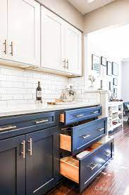 Choose a bright white to contrast a dark wood floor, such as walnut, or a slate blue stain to compliment a weathered gray expanse of planks. Classic Kitchen With Navy And White Cabinets White Subway And Wood Flooring White Kitchen Design Kitchen Cabinet Colors Kitchen Design