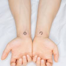 This moon tattoo is pretty simple, with a sleeping face and shading. Minimalist Matching Sun And Moon Tattoo On The Wrist