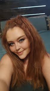 Mykelti's hair color appears to be a muted red