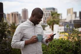 Our balustrades are manufactured in south africa and can be viewed at our showroom in blackheath, between cape town and. Side View Close Up Of A Young African American Man Standing Outside On A Balcony In The City Holding A Cup Of Coffee And Looking Down At His Smartphone Smiling Coronavirus