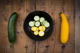 It occurs in several varieties, which range in color from deep yellow to dark green. Yellow And Green Zucchini And Bowl Of Zucchini Slices On Wood Stockphoto