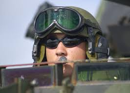 US Marine Corps (USMC) Lance Corporal (LCPL) James Buttrey, piers through  the drivers hatch of his Light Amphibious Vehicle (LAV -25) while