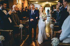 Mujer que sostiene en brazos al niño que ha de ser bautizado hasta el momento en que, al iniciarse la ceremonia, lo toma la madrina. Como Entran Los Novios A La Iglesia Protocolo Nupcial