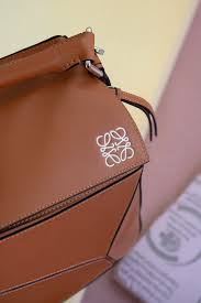 This loewe puzzle pochette bag leather mini, crafted in blue leather, features detachable strap and zip pocket. Loewe Large Puzzle Bag Tan Garmentory