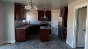 The dark grey cabinets don't feel overbearing, but rather inviting and riveting. New Kitchen Cherry Wood Cabinets Stainless Appliances Grey Walls Tall White Trim Grey Tile And Grey Walls Cherry Wood Cabinets Kitchen Cherry Wood Cabinets