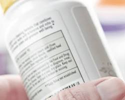 person reading the label on a bottle of pet medicineの画像