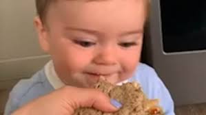 Adorable baby is annoyed for being unable to bite into sandwich