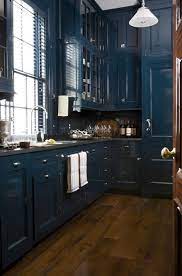 Even though the color is bold, the simplicity of the kitchen design—including the open wood shelving—stops it from becoming overpowering. Navy Cabinets Dark Blue Kitchens Blue Kitchen Cabinets Navy Blue Kitchen