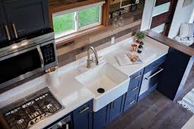 As proof, this house has a family table for work, meals, and everything else. Tiny House Kitchen With White Countertops And Blue Cabinets Hgtv