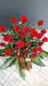 Mazzo di rose rosse a gambo lungo e verdi decorativi. Composizione In Ciotola Di Rose Rosse E Verdi Di Stagione