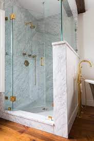 A Seamless Glass Door Accented With Antique Brass Hinges Opens To A Walk In Shower Boasting An Antiq Frameless Shower Doors Bathroom Shower Design Shower Doors