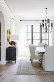 A Two Tier French Candle Chandelier Hangs Over A Rectangular Dining Table Paired With Light Gra Dining Room Design White Eclectic Dining Room White Dining Room