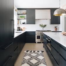 A Beautiful Modern Black Kitchen With Flat Panel Cabinetry And Marble Countertops Blackcabinetry Modern Black Kitchen Black Kitchen Cabinets Kitchen Cabinets
