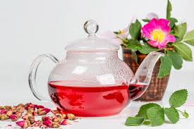 Pouring tea in glass teapot and cup with steam on wood background. Glass Teapot With Red Tea And Tea Rose Flowers On A White Background Creative Commons Bilder