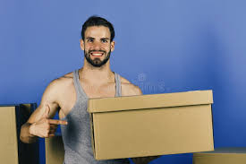 Mann Unter Kästen Zeigend Auf Seine Genitalien Bedeckt Durch Karton  Stockfoto