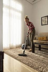 Woman Hoovering Floor In Apartment By Milles Studio For Stocksy United