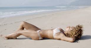 Woman lying and sunbathing on beach Stock Photo by ©dashek 103528040
