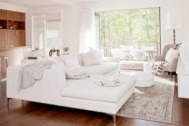 Adding a mirror to the wall behind your sofa will create the illusion of a larger space, accentuate the height of your ceilings and reflect the decorative accents on the opposite side of the room for maximum beauty. White Sectional Transitional Living Room The Cross Decor Design