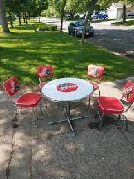 The bar height table has a glass top framed in red metal, red metal tube frame with four curved table top supports and legs. Coca Cola Table And Chairs Set June Consignment K Bid