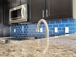 Black wood cabinetry surrounds range with beige tile backsplash in this detailed kitchen. Cheap Glass Tiles For Kitchen Backsplashes Whaciendobuenasmigas