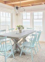 Fantastic monochromatic dining space with weathered x base table, striped rug, a pair of pendants and black dining chairs Home Decor Ideas Grey Beach House Interior Beach House Chairs Coastal Dining Room