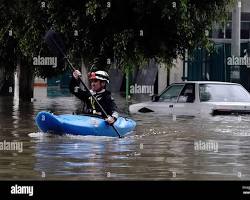 Image of person kayaking through a flooded street