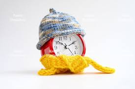 Instead of the usual numbers or hands ticking by, the knitting clock knits a mesh/stitch every half hour, finishing an entire circle/row in one day. Alarm Clock In Knitted Wool Hat And Scarf Winter Time 634777 General Design Bundles