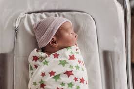 The delivery room is a flurry of activity after a birth. Newborn Baby Boy In Coming Home Outfit Held By Dad On Hospital Bed Stockphoto