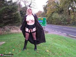 British Milf Barby opening her long coat flashing drivers as they pass by 