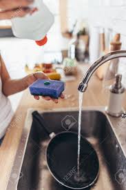woman putting cleanser to a sponge to