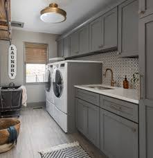 Charcoal gray laundry room features charcoal gray louvered cabinets adorned with brass handles built above stacked gray drawers adorned with vintage brass ring hardware situated next to a dry erase calendar. Floor To Ceiling Laundry Room Cabinets Houzz