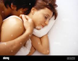 Uomo, bacio o donna che dorme nel letto per stanchezza, pace o sognare di  rilassarsi in vacanza. Coppia, amore romantico o moglie stanca in pausa  Foto stock - Alamy
