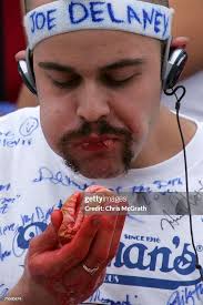 Patrick Bertoletti of Chicago stuffs hotdogs in his mouth during the...  News Photo
