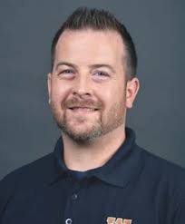 WMU's President, Dr. Edward Montgomery, driving the Bronco Baja vehicle in  front of The College of Engineering and Applied Sc