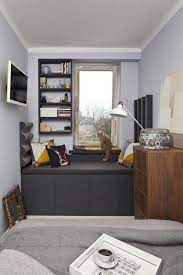 Charming patterns and fresh white accents adorn a solid grey base bedroom. Small Bedroom Furniture Gray Window Bench Storage Cabinets Wall Shelf Light Gray Wall Color Small Bedroom Furniture Small Bedroom Layout Small Bedroom