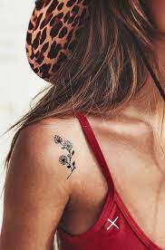 The tattoo is a circle with a botanical design. Best Locations For Small Tattoo Designs Tattoos For Women Women Tattoo Placement Tattoos Small Shoulder Tattoos