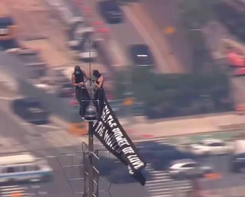 Couple climbs Empire State Building spire, hangs peace banner and gets  engaged