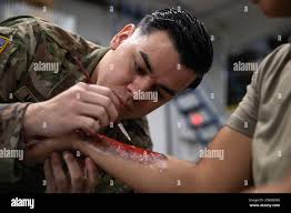 U.S. Army Reserve Spc. Steven Miranda, a chemical, biological,  radiological, and nuclear specialist assigned to the 7453rd Medical  Backfill Battalion, applies fake blood during a moulage exercise as part of  Exercise Global
