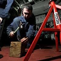 Machinist's Mate 3rd Class Travis Allen examines a