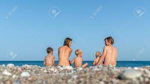 Young Family Of Five Sitting On A Pebble Beach In Beautiful Greece With  Their Backs To The Camera Enjoying Their Holidays. Stock Photo, Picture and  Royalty Free Image. Image 119093865.