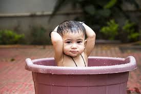 Indian traditional style baby infant bath on leg. Teaching Your Kid To Take A Bath Baby Bath Moments