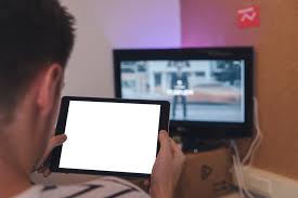 Download Man Holding Tablet In Front Of Tv Mockup Mockups Generator By Riseshot