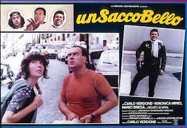 Carlo verdone, alle sue spalle la targhetta celebrativa, che recita: Stasera Alle 21 Su Iris Un Sacco Bello Di Carlo Verdone