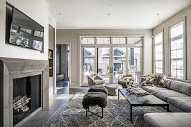 This living room showcases white seats and a modern fireplace fixed to the stone brick accent wall lined with a wooden mantel that's topped with a black canvas. Gray Living Rooms Contemporary Living Room